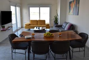 a living room with a wooden table and chairs at Panoramic Penthouse in Mağusa