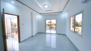 バンジュールにあるHappiness House Gambiaの白い壁と窓が特徴の空間 +2枚の写真