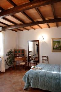 a bedroom with a bed and a table and a mirror at Agriturismo Il Casalone in Montepulciano