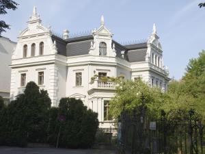 een wit huis met een zwart dak bij Ferienwohnung Villa am Stadtpark in Görlitz