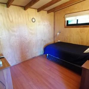 a bed in a room with a wooden floor at Casa campo in Futrono
