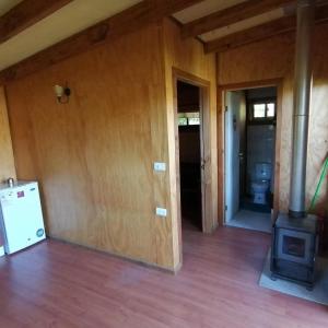 an empty room with a stove in a house at Casa campo in Futrono