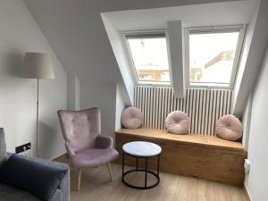 a living room with a chair and a window at A top-floor modern apartment Located 100 meters from the beach in Fuengirola +19 photos