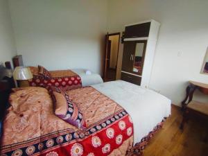 a hotel room with two beds and a mirror at Rincon Arrayán in Otavalo