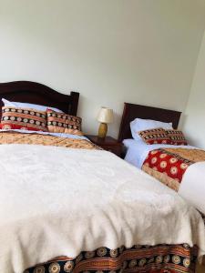 two beds sitting next to each other in a bedroom at Rincon Arrayán in Otavalo