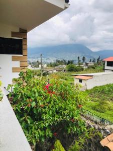 uma vista da varanda de uma casa com flores em Rincon Arrayán em Otavalo