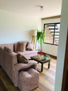 a living room with a couch and a table at Rincon Arrayán in Otavalo