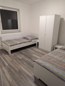 a room with two beds and a window and a tv at La vins Apartments in Bremen
