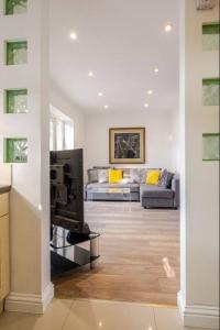 a living room with a couch and a television at Spacious 2BDR Apartment, WIFI+ Great TV in Romford +25 photos