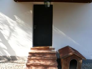 uma casa com uma porta preta e uma casa de cão em Villetta Aleanto em Mentana