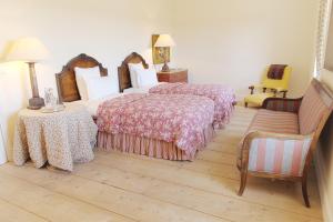a bedroom with two beds and a chair and a couch at Château du Tertre in Arsac