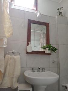 a bathroom with a sink and a mirror at CaBaña Loft 400 m BaLneario CeNtro Estacion Rio in Huerta Grande +37 photos