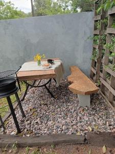 a picnic table and a bench in a backyard at CaBaña Loft 400 m BaLneario CeNtro Estacion Rio in Huerta Grande