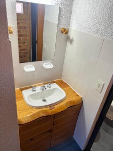 a bathroom with a sink and a mirror at Aldea Bolsón in El Bolsón +22 photos