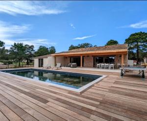 a house with a swimming pool and a wooden deck at Villa Casa di sognu in Lecci