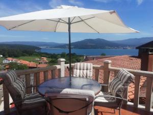 a table and chairs with an umbrella on a balcony at Casa Consuelo in Sabardes