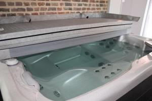 una vasca da bagno in un bagno con di Aux p'tits bonheurs la grange a Neuve-Chapelle