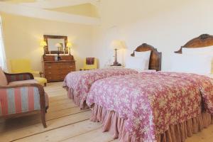a hotel room with two beds and a mirror at Château du Tertre in Arsac