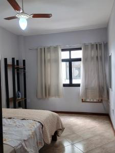 un dormitorio con una cama y una ventana en AP Varanda do Mar - Rio das Ostras, en Rio das Ostras