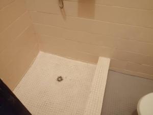 a shower with a drain in the middle of a bathroom at Beau séjour by Mannher in Yaoundé