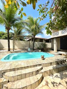 a swimming pool with a cat sitting in front of it at Casa de praia na caueira com piscina in Itaporanga dʼAjuda