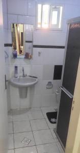 a white bathroom with a sink and a toilet at Casa de praia na caueira com piscina in Itaporanga dʼAjuda