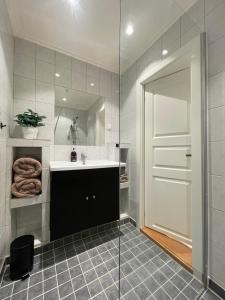 a bathroom with a sink and a glass shower at Quiet apartment, trendy Grünerlokka in Oslo