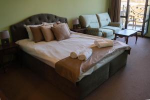 a bedroom with a large bed with towels on it at Villa Ovcharovo in Targovishte