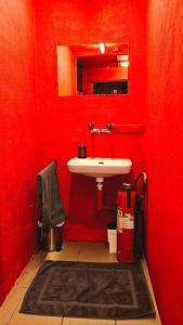 a red bathroom with a sink and a mirror at Erwachsenen Zimmer, Spielzimmer, Playroom in Neuhausen am Rheinfall