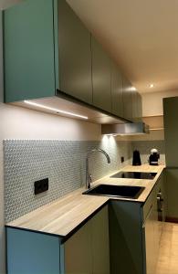 a kitchen with green cabinets and a sink at Meribel Centre Mountain View in Mussillon +3 photos