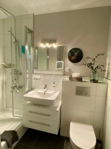 a bathroom with a sink and a shower and a toilet at Seeblickappartement -Eure Zeit- mit Balkon in Goslar