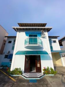 里约达欧特拉斯Suites Recanto dos Charri的白色的建筑,设有窗户和阳台