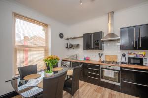 a kitchen with a table and a dining room at Stylish 91sqm Victoria 2 bedroom Apartment in Bristol