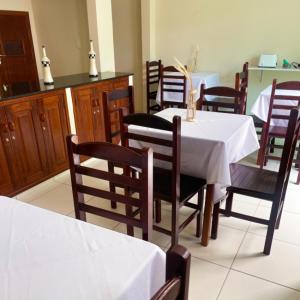 a dining room with a white table and chairs at Pousada Recanto dos Charri in Rio das Ostras