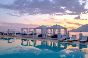 a pool with chairs and tents next to the water at Lukka Exclusive Hotel – Adult Only +12 in Kaş