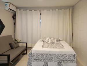 a bedroom with a bed and a couch and a window at A 5 km do aeroporto no centro do Nucleo Bandeirante 156 in Brasilia