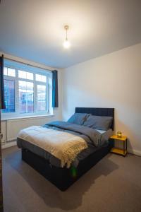 ein Schlafzimmer mit einem Bett und einem Fenster in der Unterkunft Urban Luxe Stays - Purbrook Bridge in London