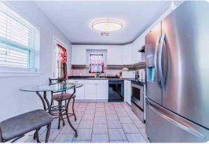 a kitchen with a table and a stainless steel refrigerator at Pet friendly 3 bedroom house in Oklahoma City