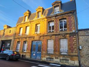 a yellow brick building with a car parked in front of it at Suite Delvincourt - Rue Calme centre ville - Parking gratuit - Proche Gare in Charleville-Mézières