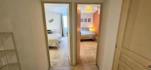 a view of a bedroom with two beds and a mirror at NEW! Wifi, Netflix Le Refuge des Berges in Beaucaire