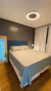 a bedroom with a large bed with a blue headboard at JB301 - Apê lindo e econômico in João Pessoa +16 photos