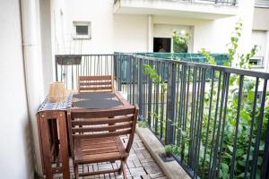 ein Tisch und zwei Stühle auf einem Balkon in der Unterkunft Appartement 4 chambres proche Stade de France, parking et balcon sur jardin in Aubervilliers