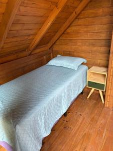 a bed in a room with a wooden ceiling at Pousada Chalé Flor de Hibisco 1 in Penha