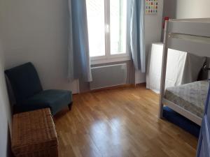 een slaapkamer met een bed, een stoel en een raam bij Rue sebastien spacious apartment close beach in Banyuls-sur-Mer
