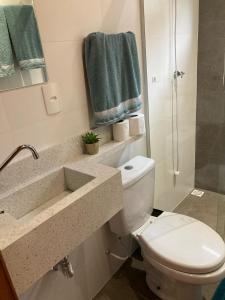 a bathroom with a toilet and a sink and a shower at Pousada Chalé Flor de Hibisco 1 in Penha +19 photos