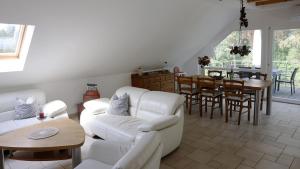 a living room with white furniture and a dining room at Ferienwohnung Bestensee in Bestensee