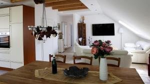 a kitchen and living room with a vase of flowers on a table at Ferienwohnung Bestensee in Bestensee +10 photos