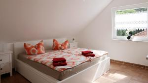 a bedroom with a bed with orange pillows and a window at Ferienwohnung Bestensee in Bestensee