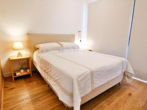 a large white bed in a bedroom with a wooden floor at Modern & Bright Studio in Asuncion +15 photos