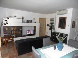 uma sala de estar com um sofá e uma televisão em Trilocale I Meridiani Le Maree 4T em Cannigione